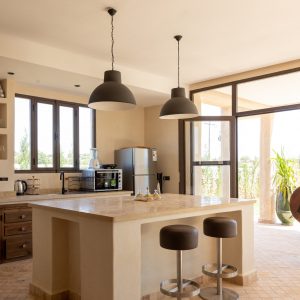 Cuisine ouverte de la Villa Alborán avec îlot central et tabourets hauts