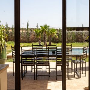 Terrasse couverte de la Villa Alborán avec table à manger de huit places face à la piscine