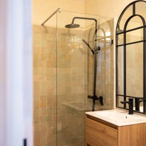 Salle de bain de la Villa Alminar en zellige vert d'eau avec fenêtre en arche